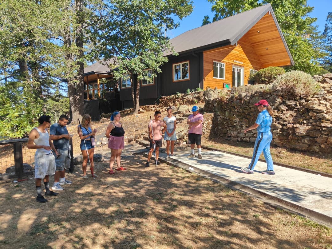 A player demonstrating the visually impaired people about blind cricket.