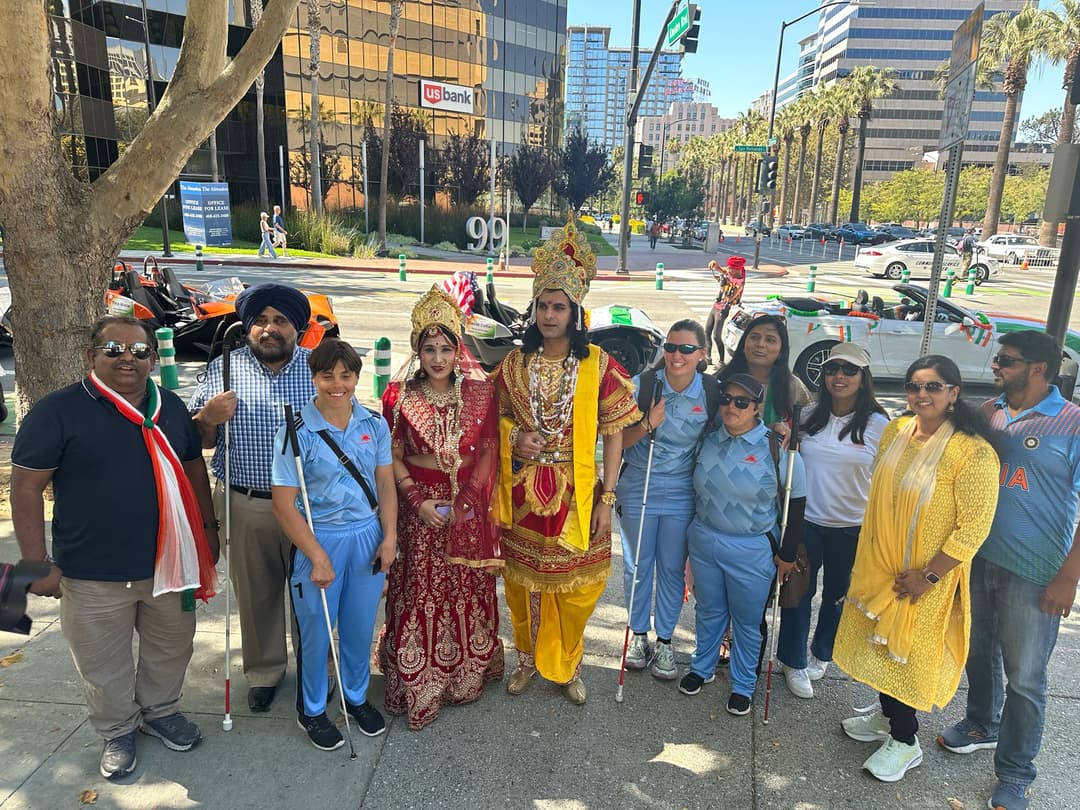 A group photo where 2 persons have dressed up as lord Krishna and Radha.